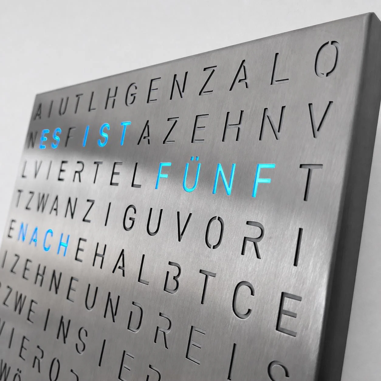 Türkis leuchtende Buchstaben auf der gebürsteten Edelstahlfront in Nahaufnahme